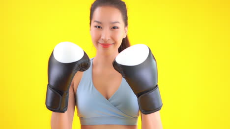 Close-up-of-pretty,-young-woman-wearing-boxing-gloves-and-throwing-punches