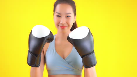 close up of pretty, young woman wearing boxing gloves and throwing punches