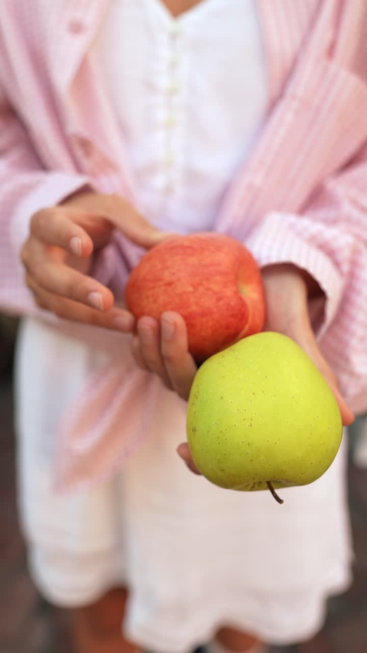 빨간색 과 초록색 사과를 들고 있는 여자