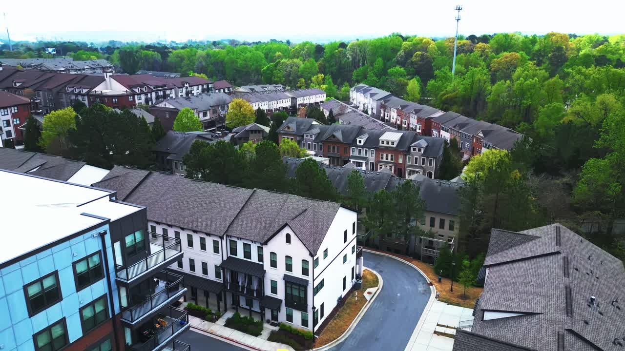 Modern and historic townhouses in suburb of american town. Green trees in spring time. Aerial orbit wide shot. New developed area with Buildings in Atlanta, Georgia.
