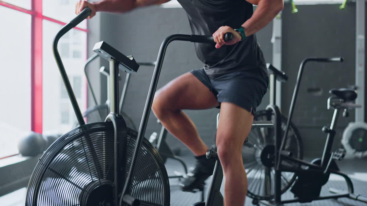 Uomo con air bike, esercizio cardio in palestra CrossFit