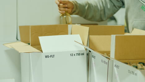 hombre empacando botellas de vino en cajas