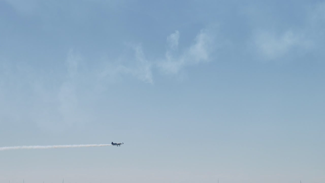 은 파란 하늘에서 스턴트를 하는 비행기