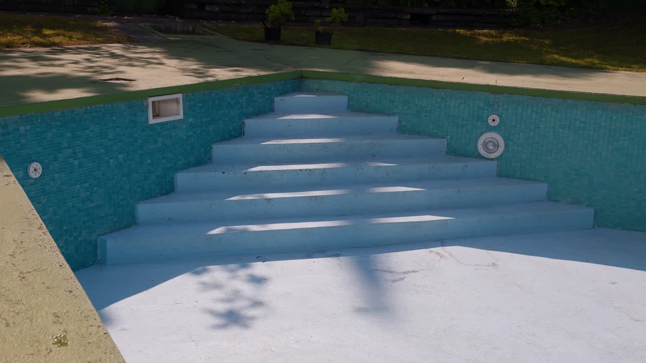 Close-up of abandoned blue-tiled pool surface in a garden at Lake Como, Italy (Lago di Como, Italia), weathered texture