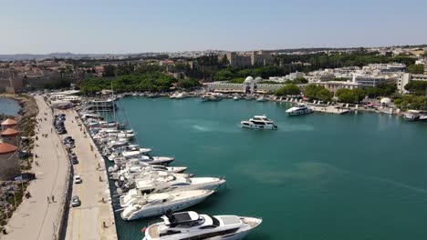 aerial orbit rhodes marina, airplane shadow in water and huge docked cruise ship