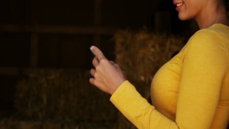 mujer usando teléfono móvil en el establo 4k