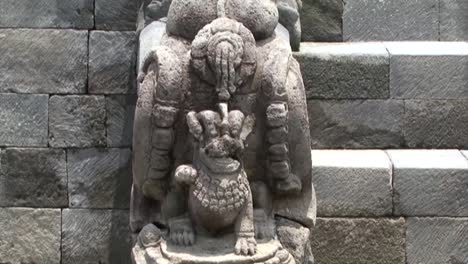 Slow-panning-on-a-statue-at-Borobudur-Temple,-UNESCO-World-Heritage-Site,-Central-Java,-Indonesia,-Buddhist-Temple