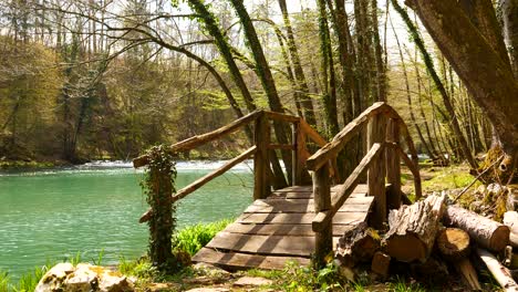 Static-shot-of-a-small-arched-wooden-bridge-across-a-small-stream-at-Krka-River