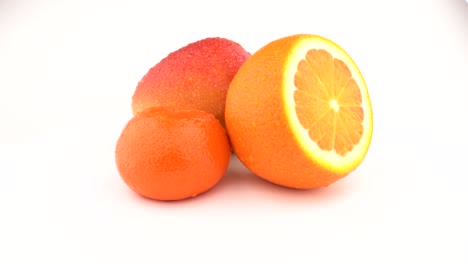 mango, frutas de naranja y frutas de mandarina girando sobre un fondo blanco. aislado. de cerca.