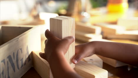 small four year old south african boy playing intently with building blocks