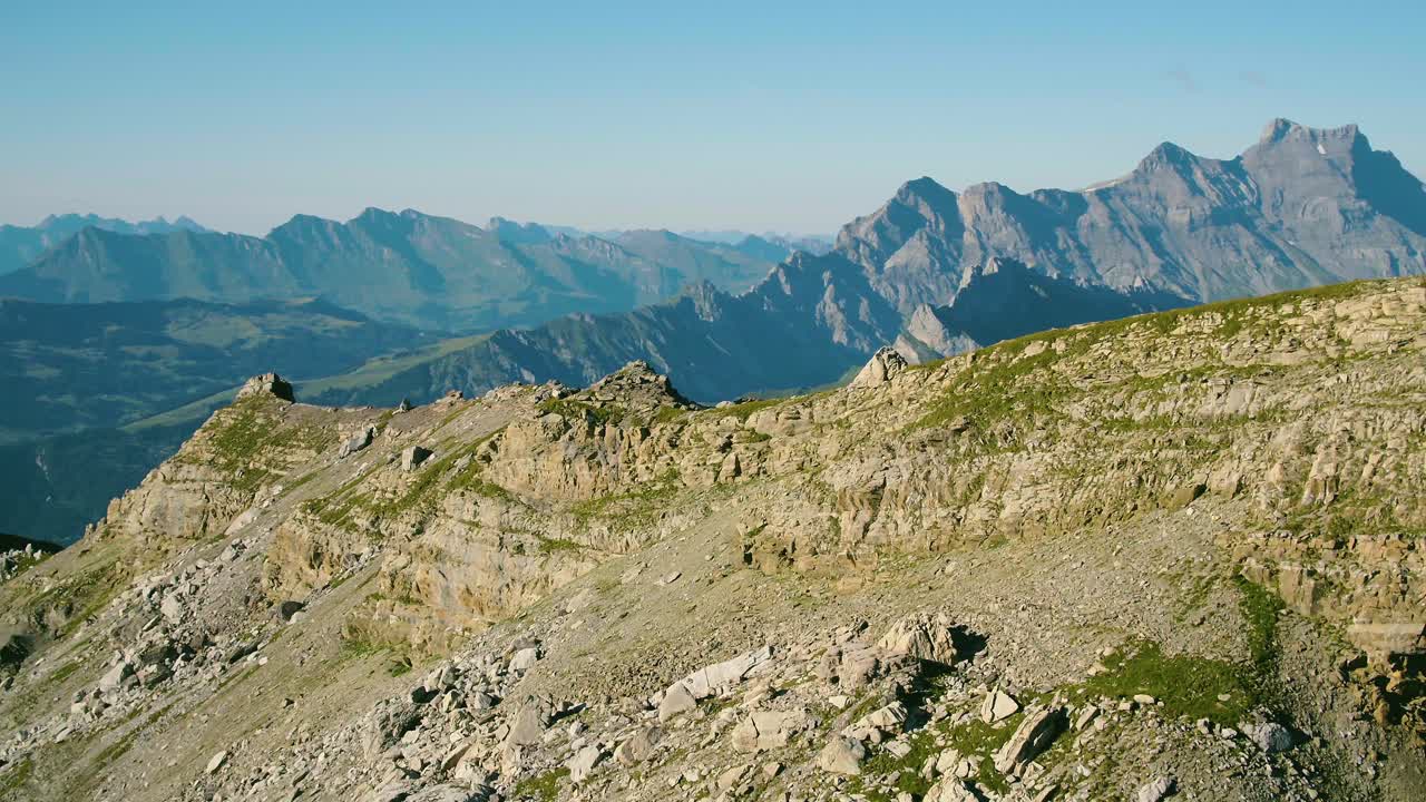 toma aérea que revela un valle profundo y una alta cordillera en el fondo tomada desde col des perris-blancs y que revela el macizo de vallon de nant y diablerets - los alpes, suiza