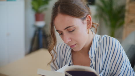 close-up of woman reading book at home