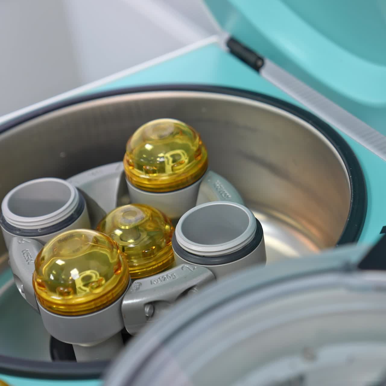 Hands in blue latex gloves put the test tube with blood into apparatus. Equipment for medical analyses in modern hospital