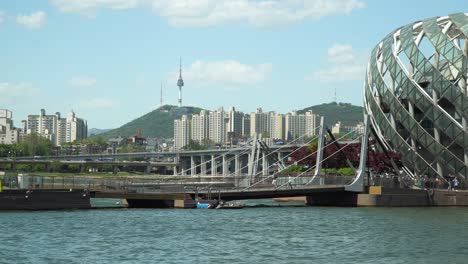 distant view of namsan tower from han river in seoul with sebitseom, artificial floating island popular in south korea