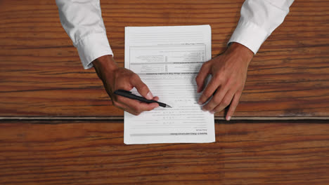 caucasian male hands writing down notes on a paper sheet