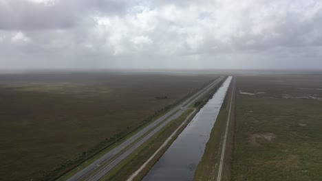 aerial view of a highway and canal through vast wetlands