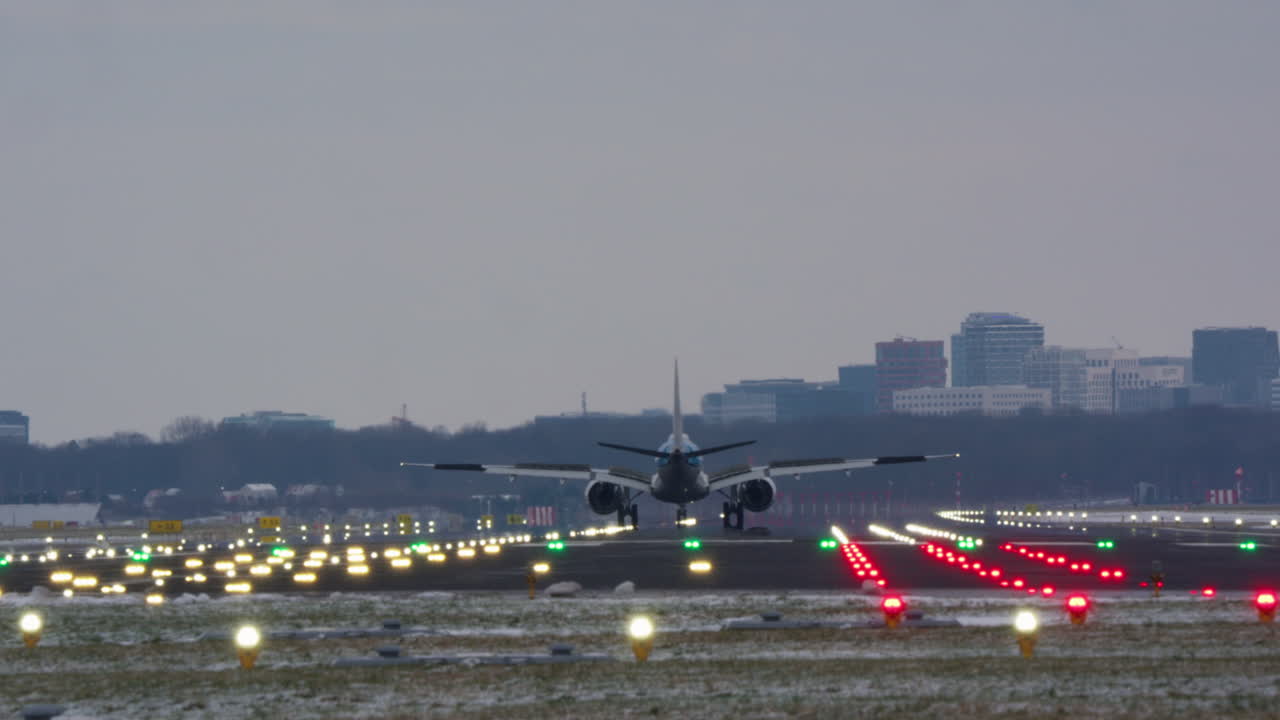 Gran avión de pasajeros aterrizando en una pista iluminada al anochecer