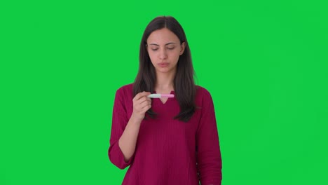 mujer india estresada tomando una prueba de embarazo pantalla verde
