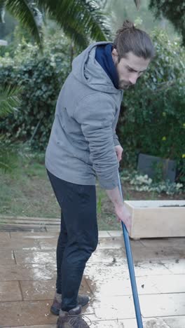 man cleaning a swimming pool and patio area