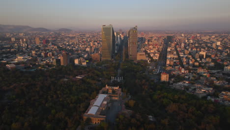 Aerial-view-of-capital-of-Mexico,-Chapultepec-Castle-in-park-Bosque-de-Chapultepec,-skyline-with-modern-high-rise-buildings-skyscrapers-landscape-panomexicorama