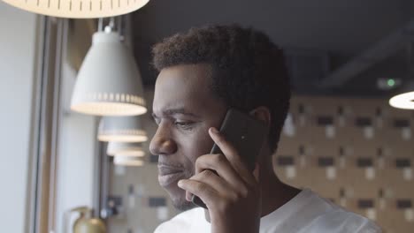 alegre joven afroamericano hablando por teléfono móvil