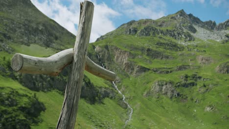 se ha construido una cruz de madera cerca de una pequeña iglesia en gressoney, en italia, frente al monte rosa y otras hermosas montañas