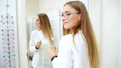 woman in optic store choosing glasses. beautiful girl wearing glasses in optician shop