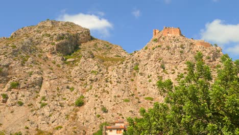 pan shot of large rock formation giving detail to the castle ruins of an ancient picturesque village, borriol, spain