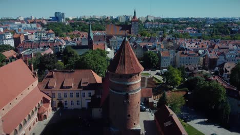 Medieval-Castle-with-an-Old-Watch-Tower-and-Amphitheatre-in-the-background,-aerial-shot