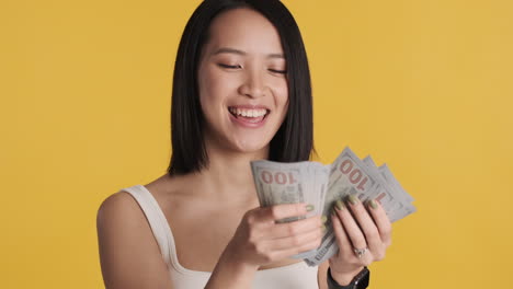 asian woman counting money on camera.