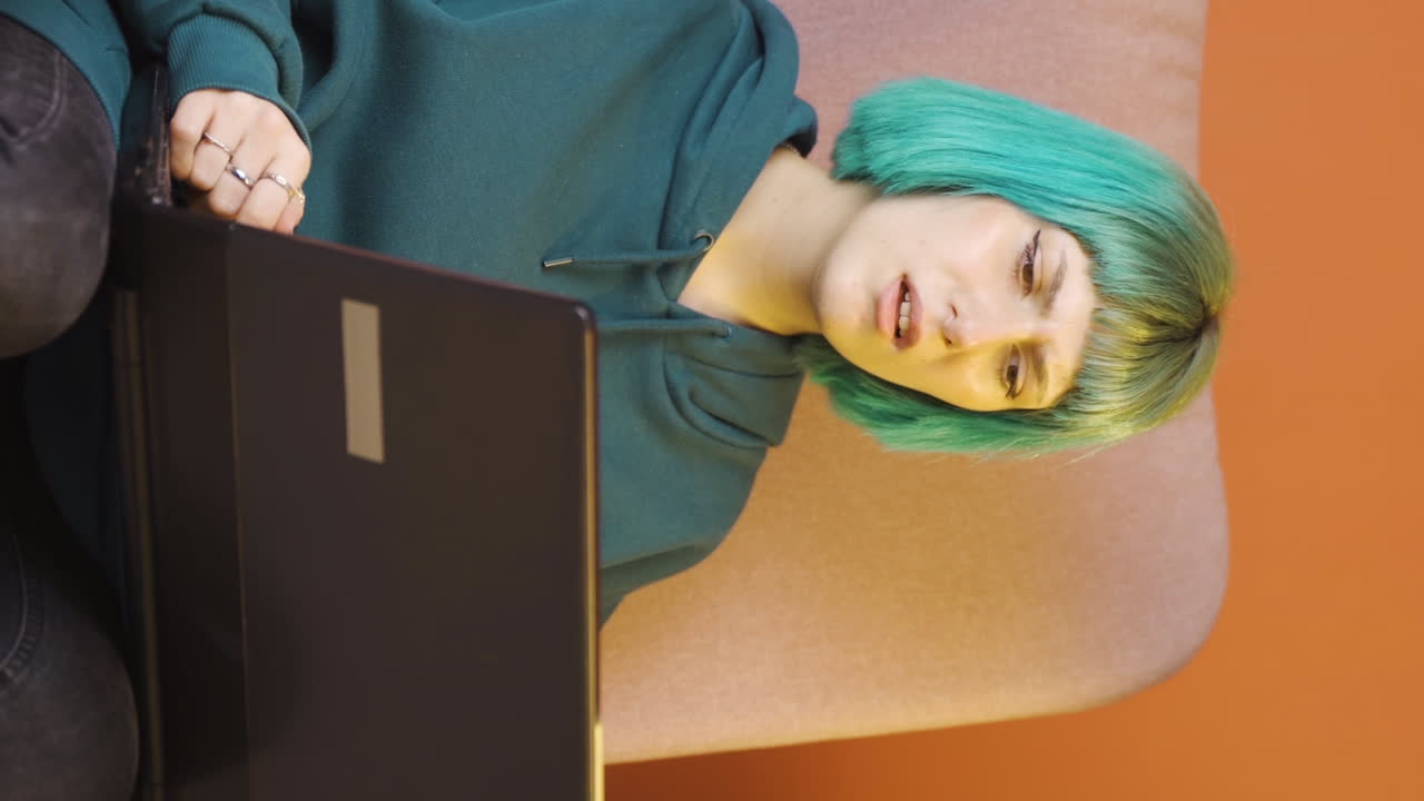 Vertical video of The young woman who can't use the application on the laptop.