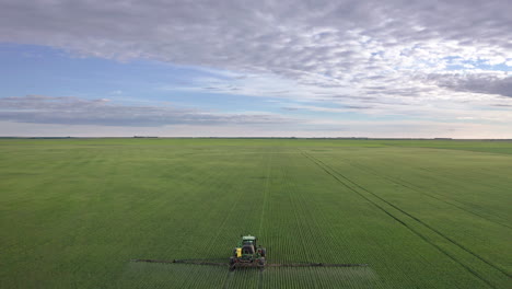 tractor spraying fungicide on large areas of cereal crops
