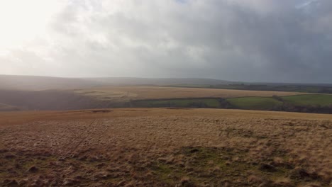 Luftdrohne-über-Die-Dunstige-Moorlandschaft-In-Exmoor-Mit-Sonneneruption-Uk-4k-Geschossen