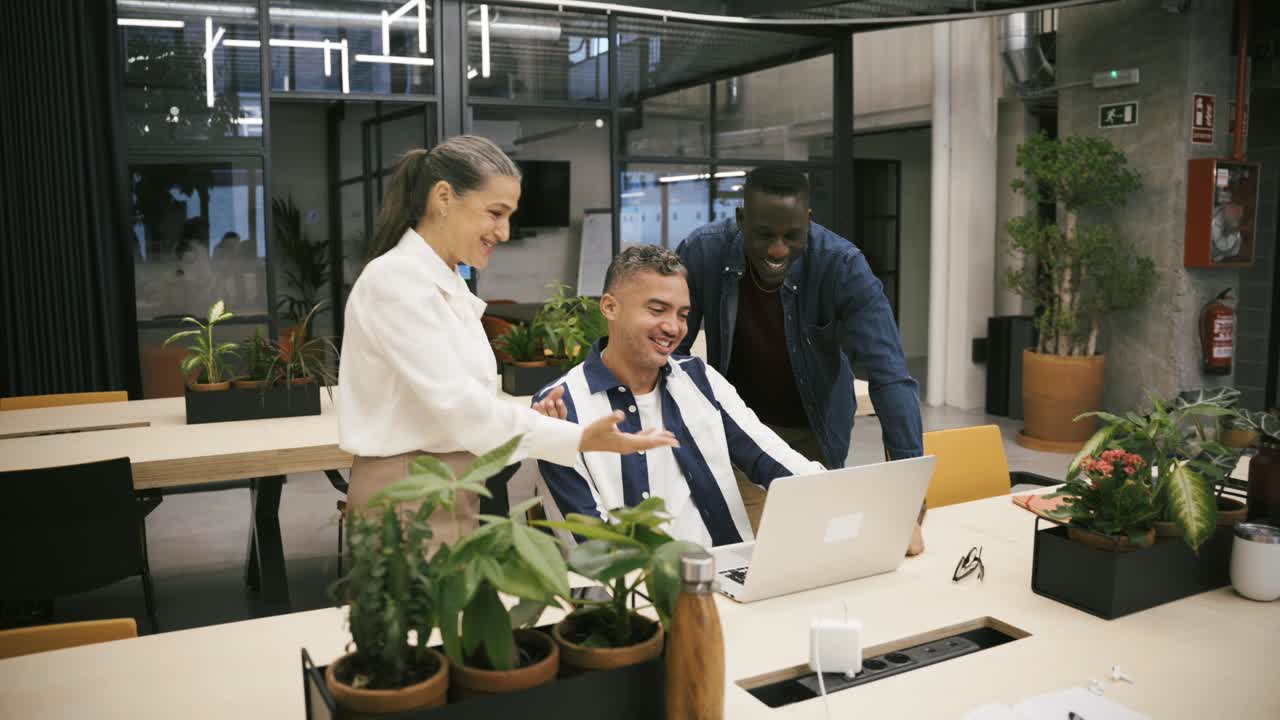 Multiracial colleagues browsing laptop together