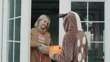 a girl in a deer costume knocks on the door, where she is then given candy