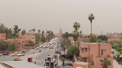 Blick-Auf-Den-Verkehr-Auf-Der-Straße-Von-Marrakesch-Und-Der-Kasbah-Moschee-Im-Hintergrund,-Marokko