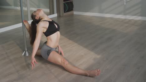 Caucasian-woman-stretching-before-pole-dancing