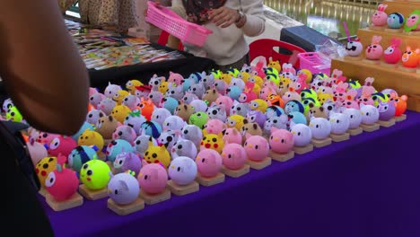 close up shot of roadside stall selling toy souvenirs in khlong hae floating market in songkhla province, thailand on a busy day