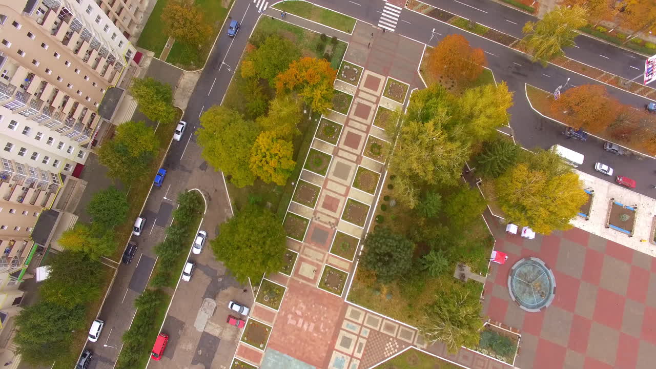 Beautiful park zone in the colors of bright autumn. Peaceful city with calm traffic among residential quarters.