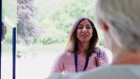 Female-care-worker-on-home-visit-showing-her-ID,-close-up