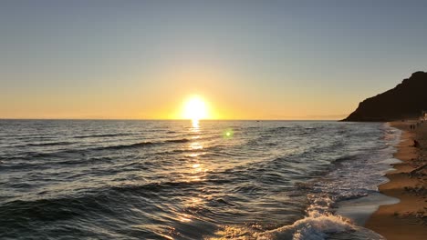 drone video reveals a trajectory towards the sun as a small boat passes through the sea