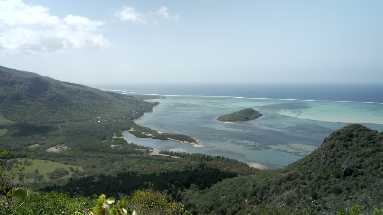 Pan right wide shot of beautiful natural landscape with blue bay lagoon beside sea shore