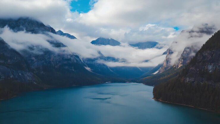 Lago di montagna maestoso con cime avvolte dalla nebbia