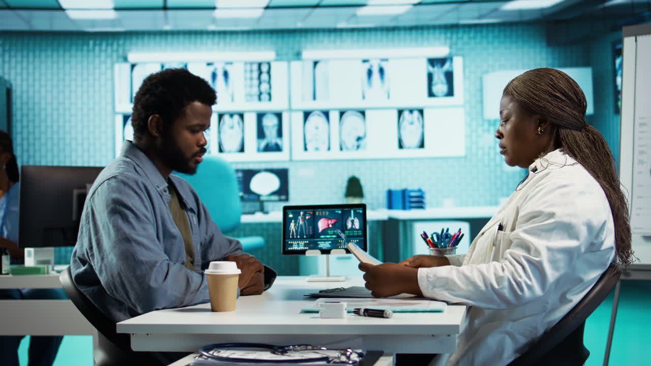 African american young man and specialist review ct scans and x rays