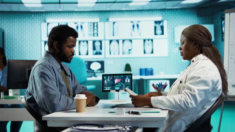 african american young man and specialist review ct scans and x rays
