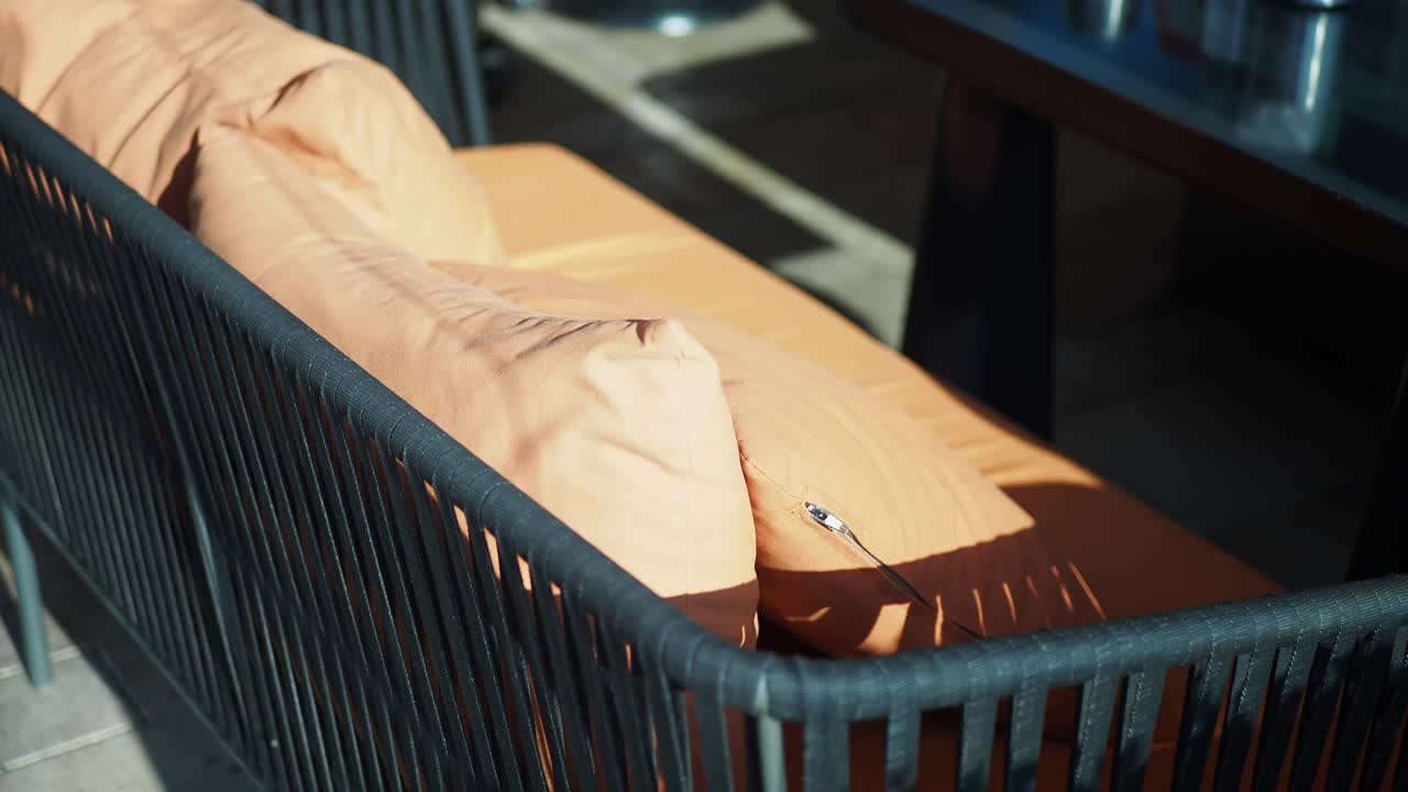 갈색 베개와 함께 야외 소파의 가까운