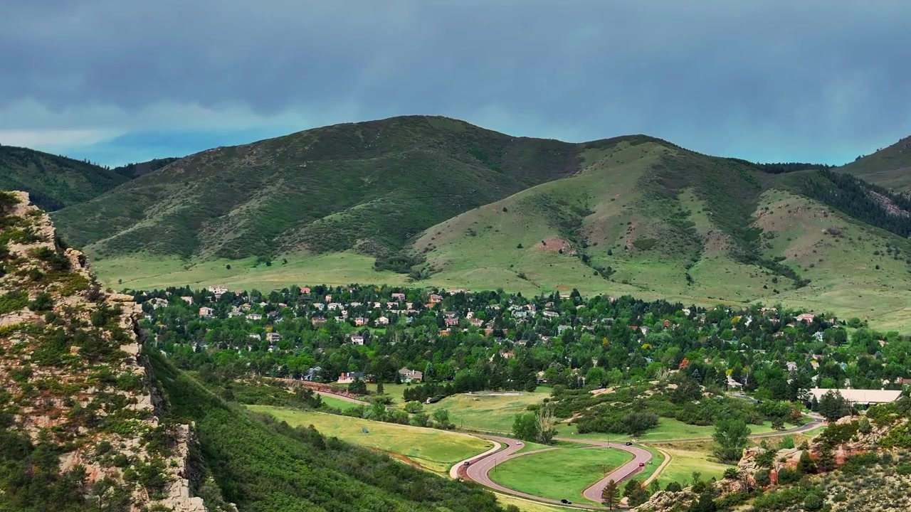 Ken Caryl Vadisi Çiftliği Hogback Sırtı Littleton Güney Vadisi girişi, Front Range Denver Colorado. Rocky Dağları eteklerinde bulutlu yaz sabahı havadan drone görüntüsü, mahalle evleri ve Meadow Ranch'e doğru