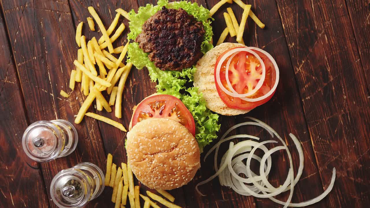 Two tasty grilled home made burgers with beef  tomato  onion and lettuce
