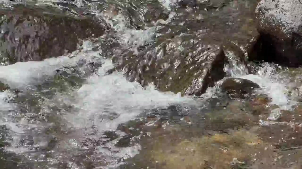 Un chiaro ruscello di montagna che scorre sopra le rocce