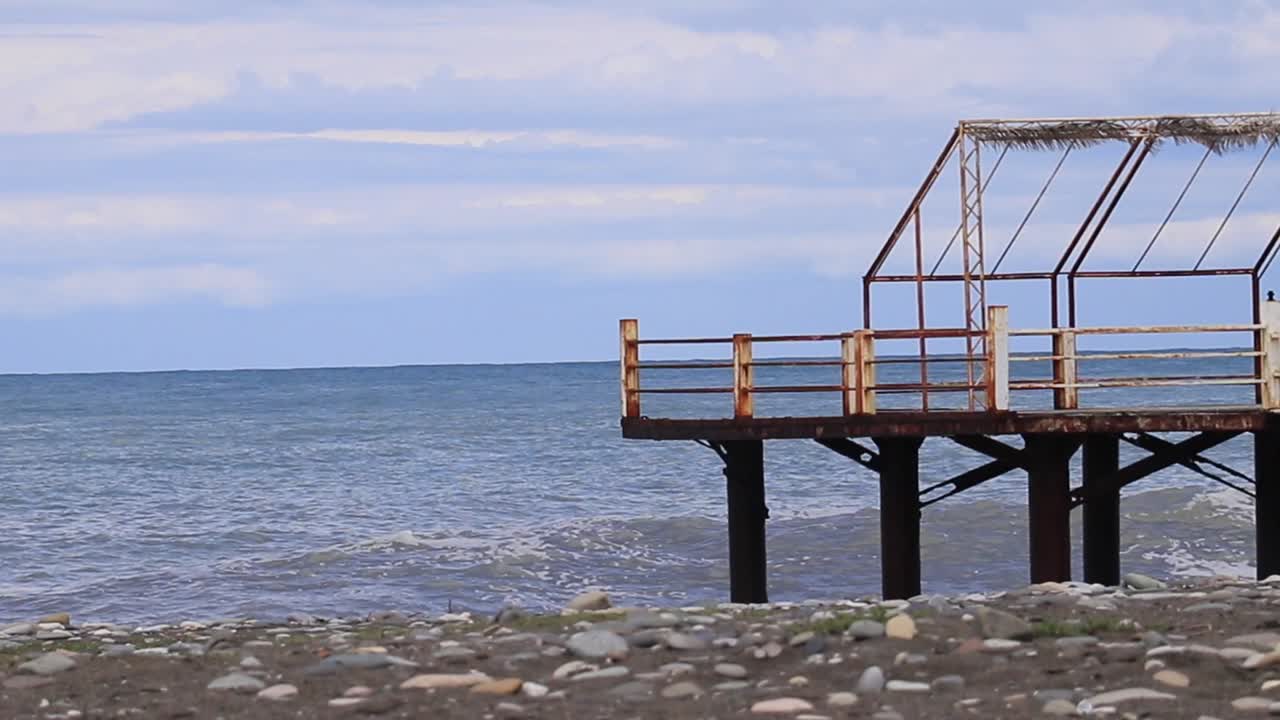 Pier on the shore of the Black Sea in Batumi, Georgia, with sea waves crashing at the coastal area, highlighting the concept of maritime beauty and coastal landscapes
